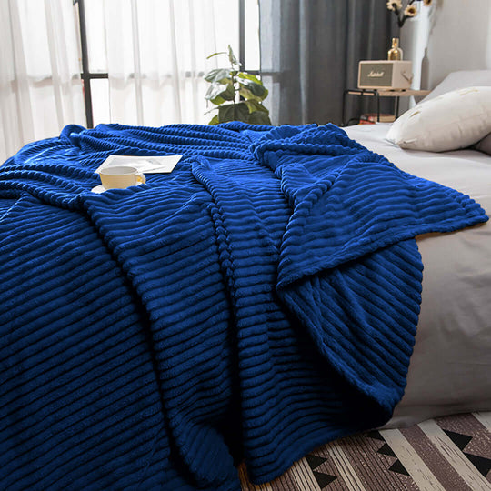 Cozy blue ribbed blanket on a bed in a modern bedroom setup