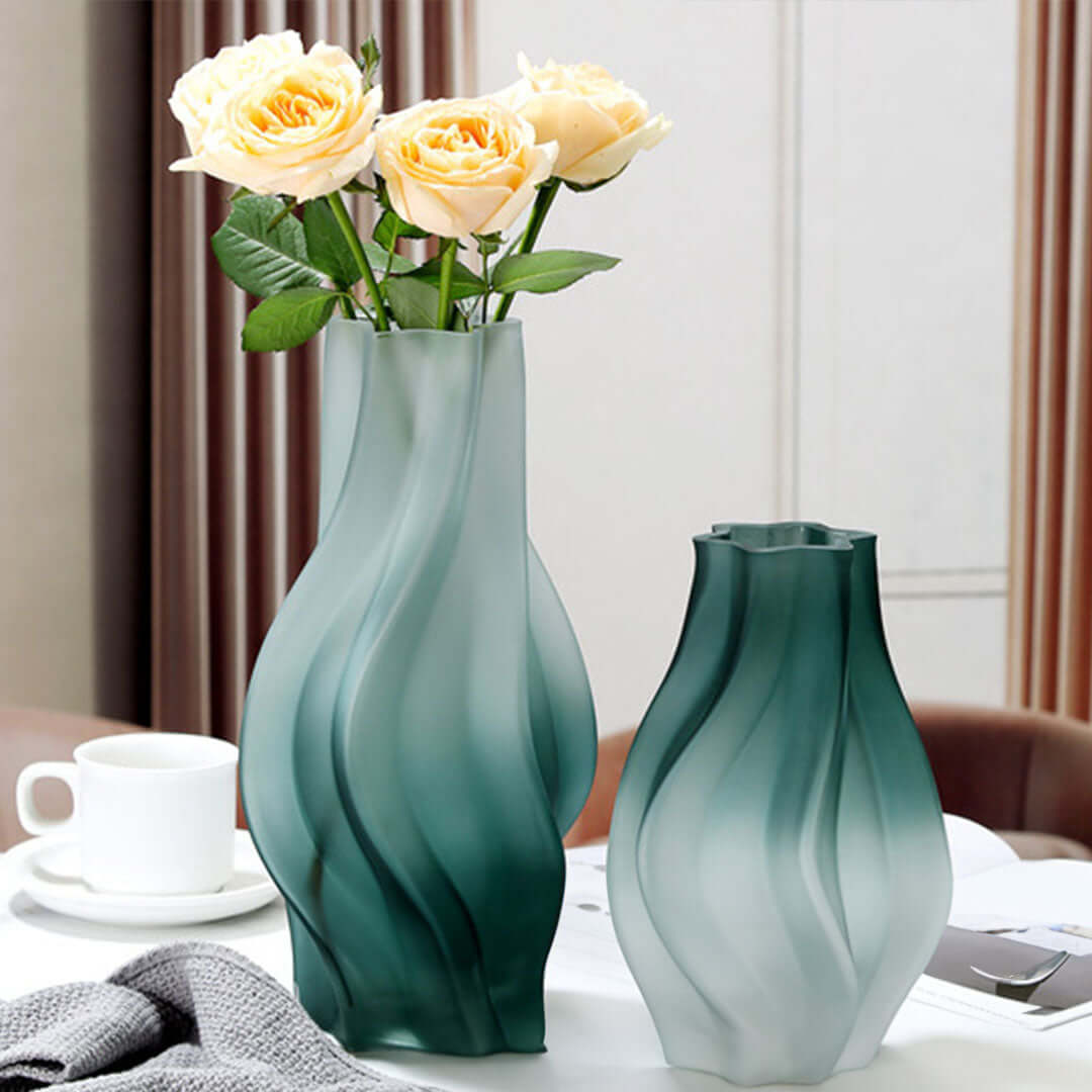 Elegant green glass vases with flowers on a table, showcasing affordable quality homewares and value furniture enhancements.