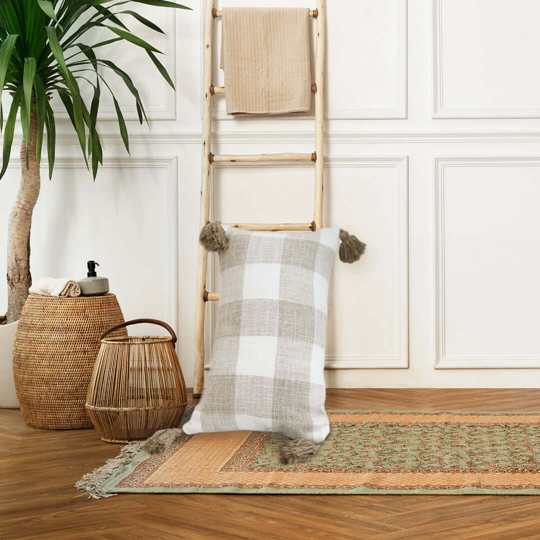 Affordable quality homewares featuring a value furniture setup with a plaid cushion, decorative ladder, and woven baskets in a cozy room.