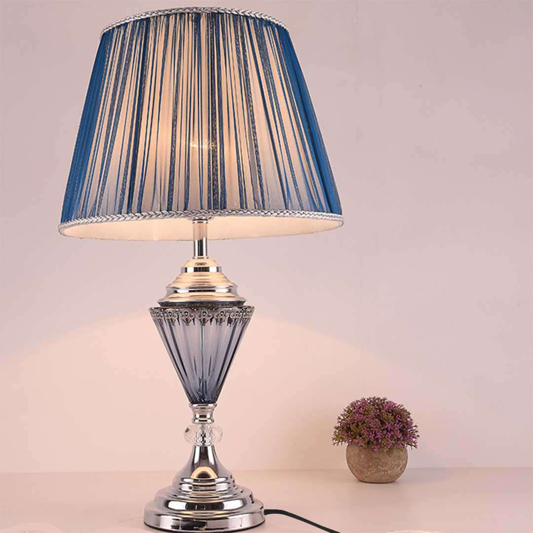 Affordable quality homewares - blue-striped lampshade on a silver lamp base, beside a small potted plant, adding value to your furniture décor.