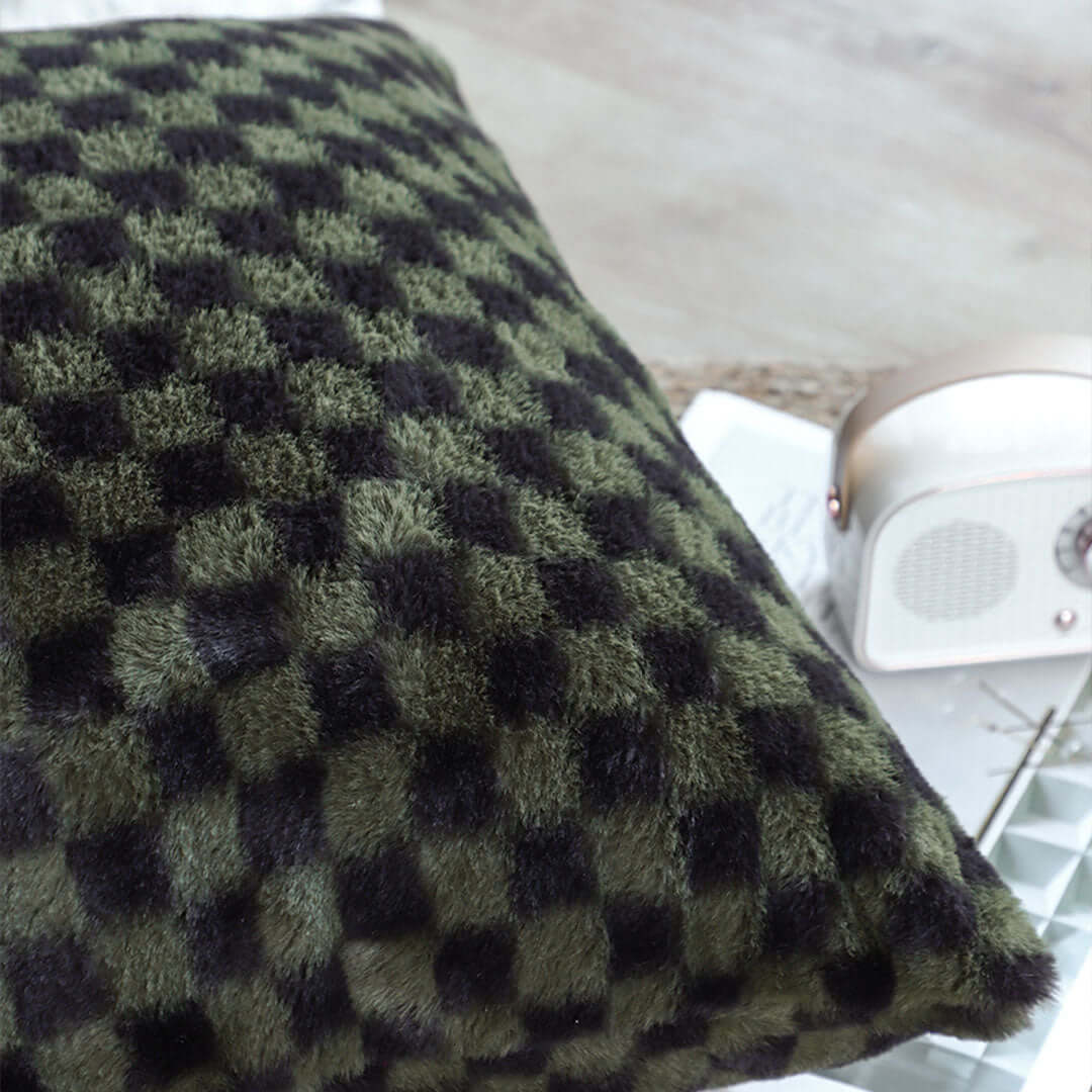 Green and black checkered textured cushion on a table next to a small white retro radio, highlighting affordable homewares and quality value furniture