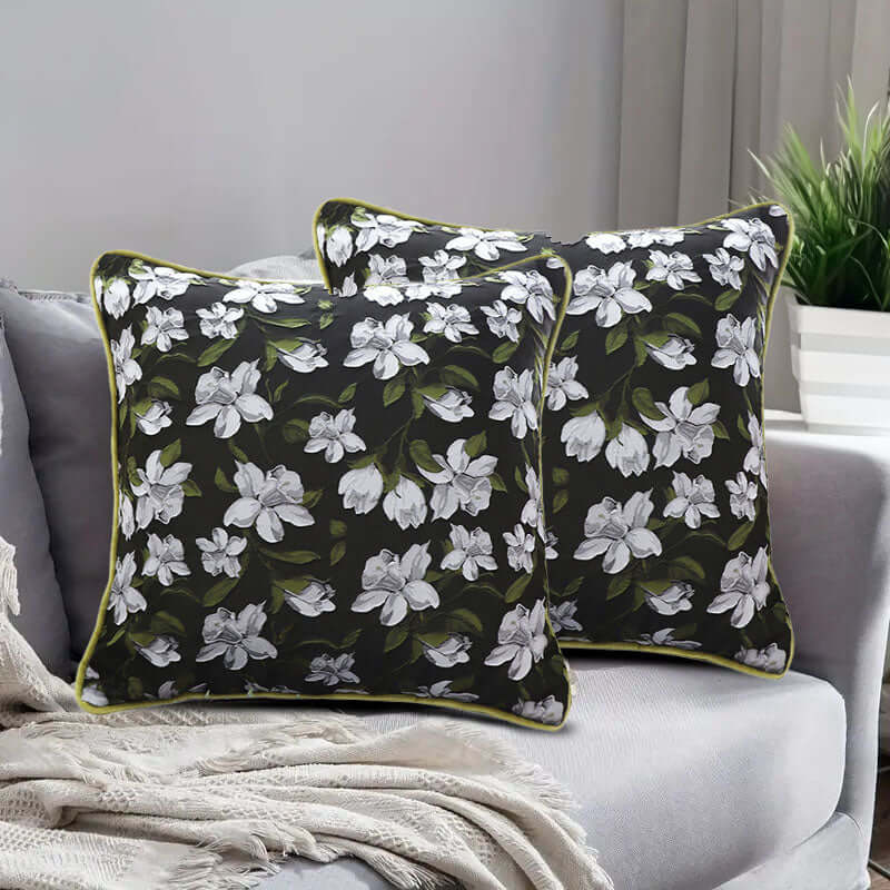 Floral black and white throw pillows on a grey couch, adding affordable and quality value furniture to home decor.