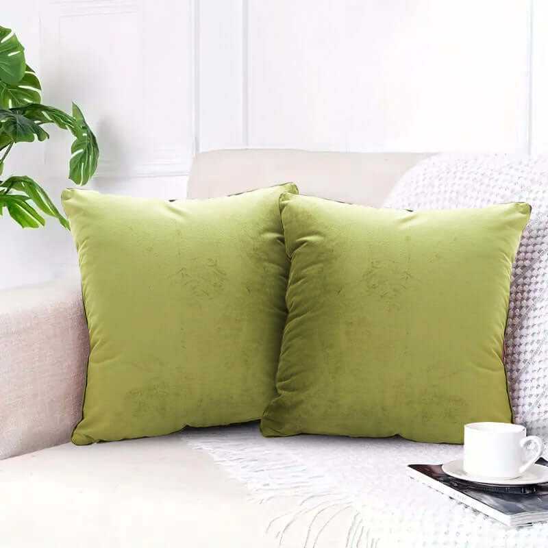 Affordable quality homewares - two green cushions on a beige sofa with a white cup and saucer, enhancing the value furniture setup.