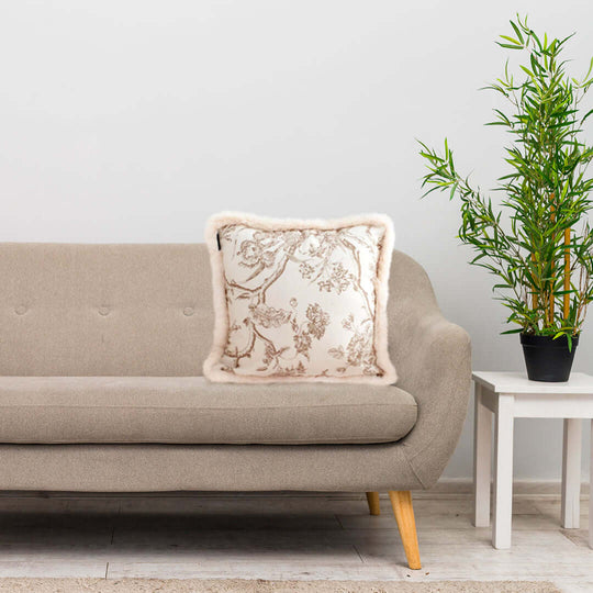 Affordable homewares showcasing a quality beige sofa with sleek wooden legs, a value furniture throw pillow, and a plant on a white side table.