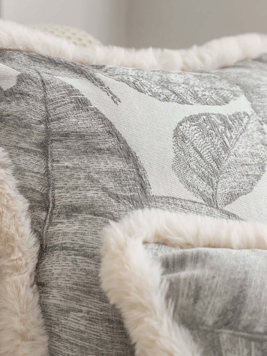 Close-up of quality and affordable homewares including a fluffy, value furniture pillow with leaf pattern.