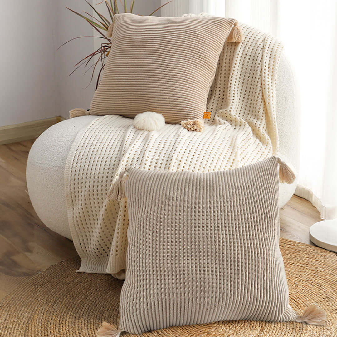 Cozy armchair with affordable high-quality knitted pillows and a throw blanket, providing value furniture for a stylish home.