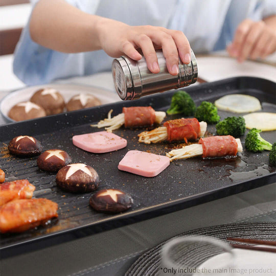 Cooking meats, mushrooms, and vegetables on a grill at home for affordable and quality home dining experience with value furniture in background.