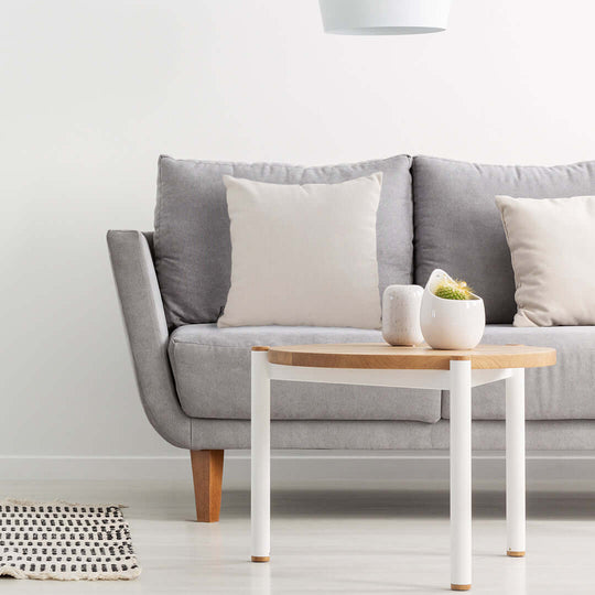 Affordable quality homewares and value furniture - stylish grey sofa with light wooden legs and pillows, paired with a minimalist coffee table