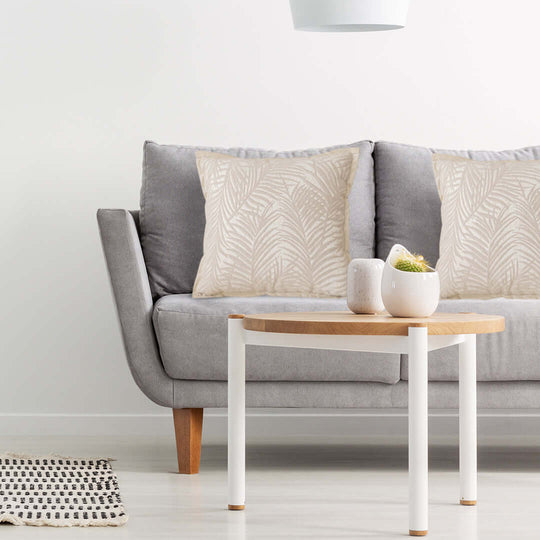 Modern living room with a gray sofa, decorative beige pillows, white round coffee table, and minimalist decor - affordable quality homewares.