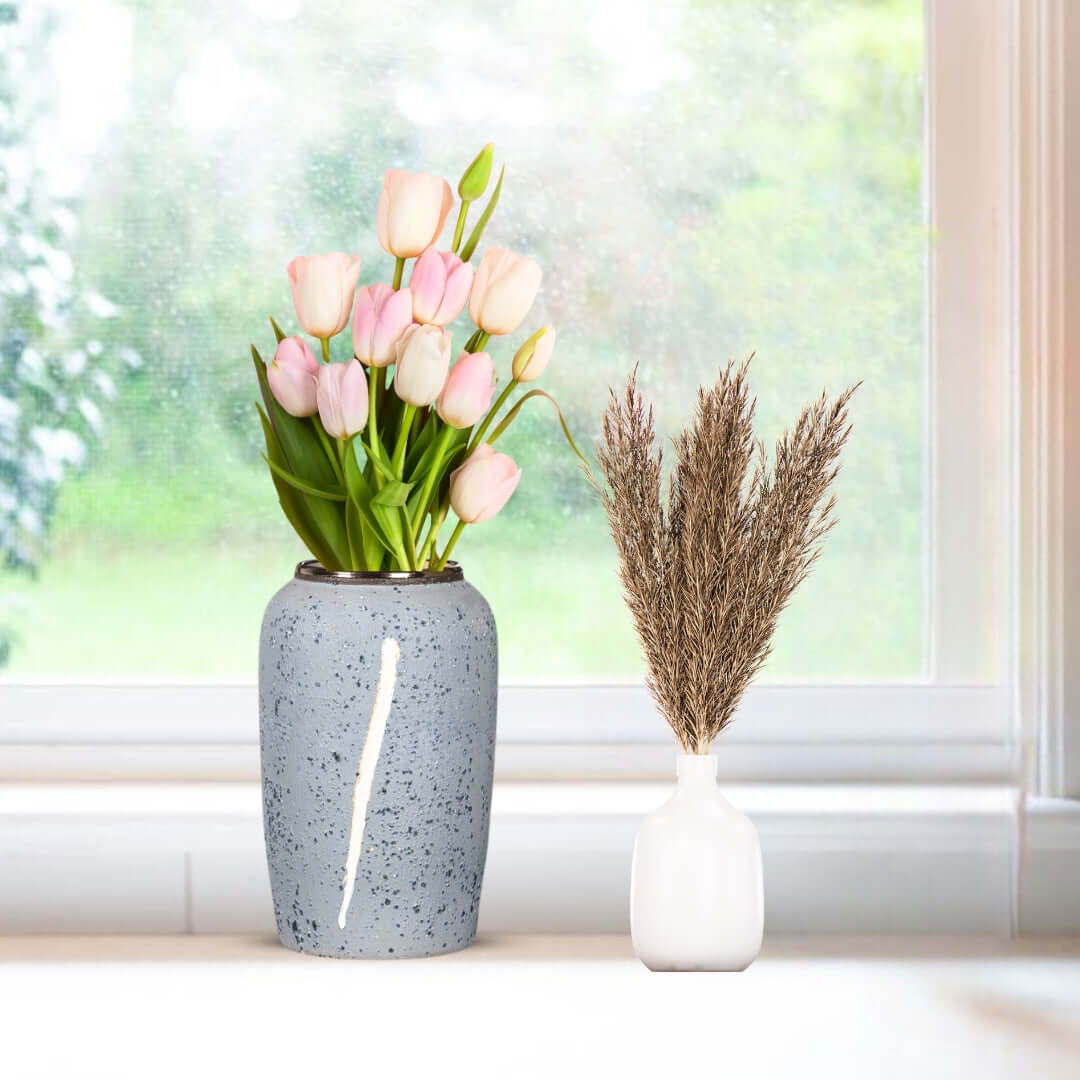 Affordable quality homewares - Blue vase with pink tulips and white vase with dried grasses on a windowsill. Value furniture and home decor.