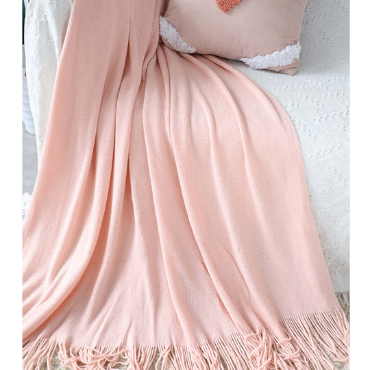 Elegant affordable peach homeware throw blanket with quality fringe detailing on a cozy value furniture setup.