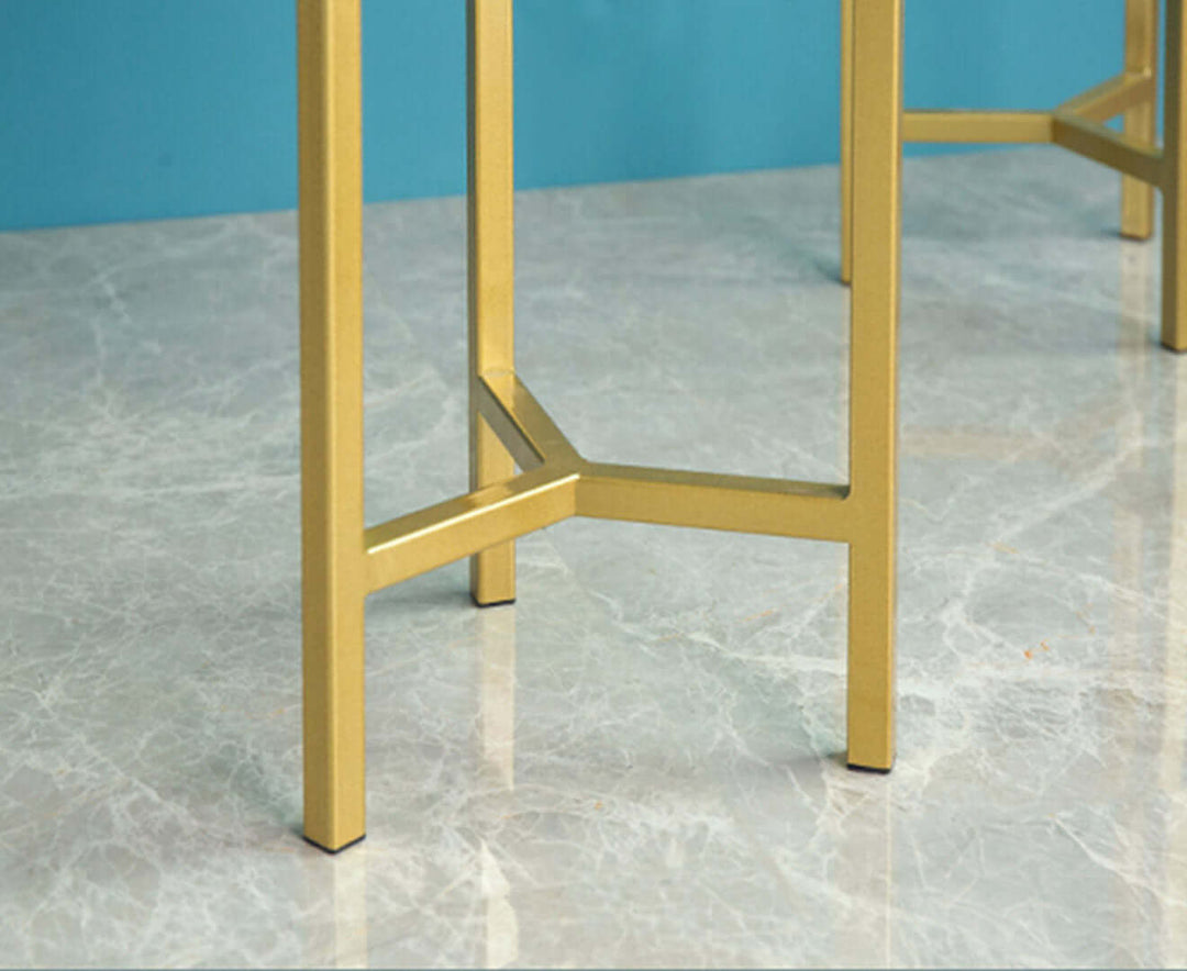 Close-up of legs of a stylish gold metal table on a marble floor showcasing affordable quality homewares and value furniture.