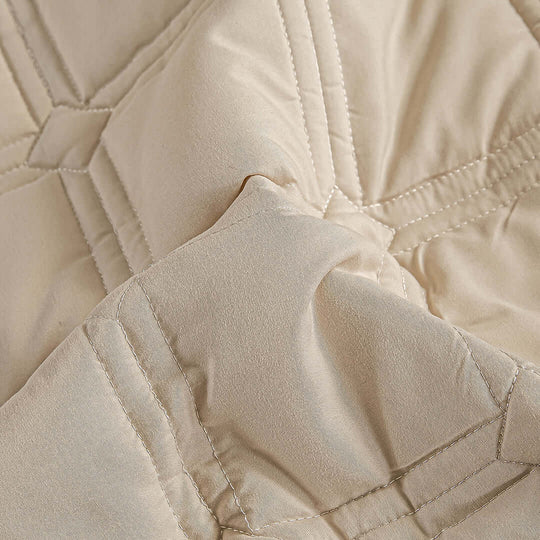 Affordable quality homewares beige quilted fabric close-up, highlighting value furniture with detailed stitching.