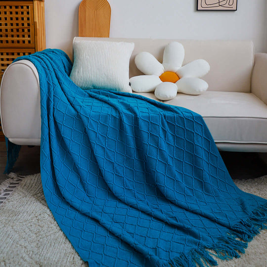 Cozy white sofa with quality blue throw blanket and flower-shaped cushion, showcasing affordable homewares and value furniture.