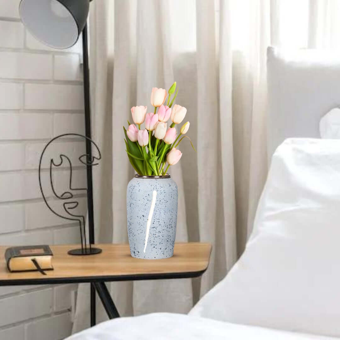 Affordable quality homewares - value furniture side table with speckled vase of pink tulips in cozy bedroom scene.