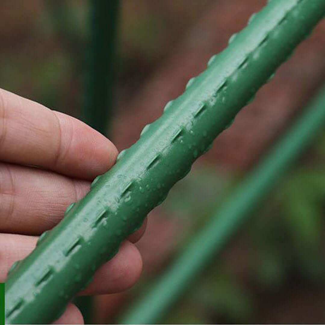 Hand holding a green textured gardening stick used for supporting plant growth