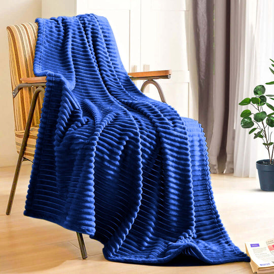 Affordable quality blue ribbed blanket draped over a chair in a cozy home setting showcasing value furniture and homewares.