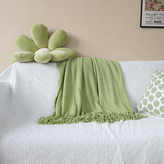 Affordable homewares - green throw blanket on white couch with green flower cushion and matching pillow, showcasing quality value furniture.