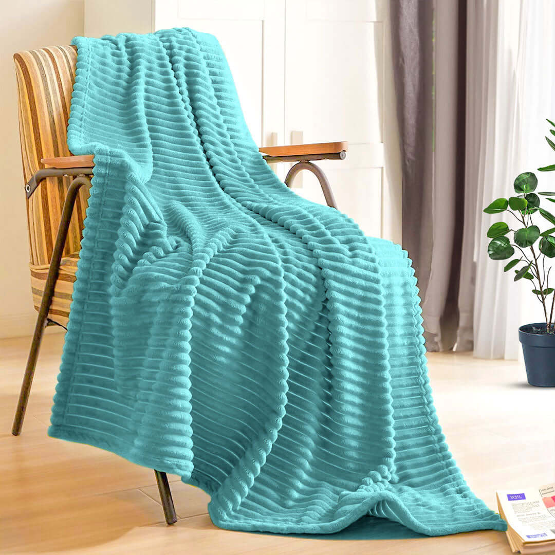 Affordable quality teal blanket draped over chair in a cozy home interior setting