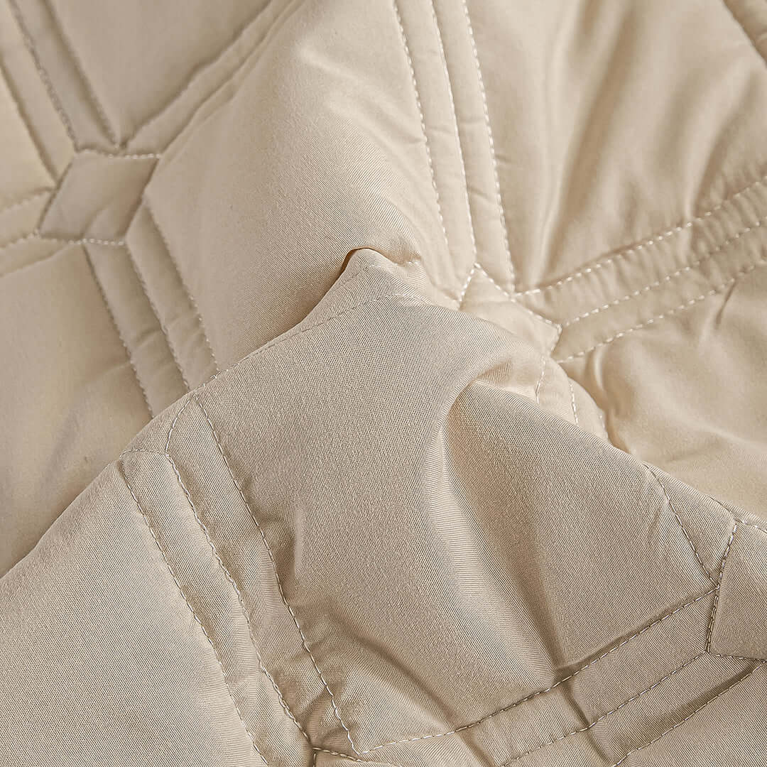 Close-up of a high-quality beige quilt showcasing its detailed stitching and soft texture, perfect for affordable homewares and value furniture.