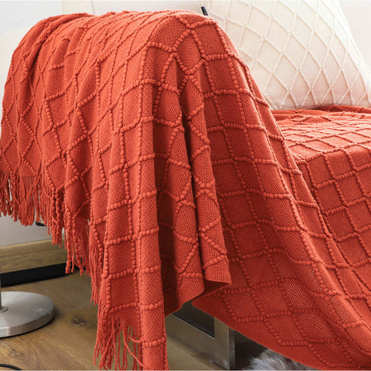 Affordable quality homewares - cozy orange knitted throw blanket draped over a chair, adding stylish value furniture to your living space.