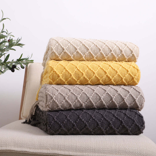 Stack of affordable, quality knit blankets in various colors, showcasing value furniture and homewares.