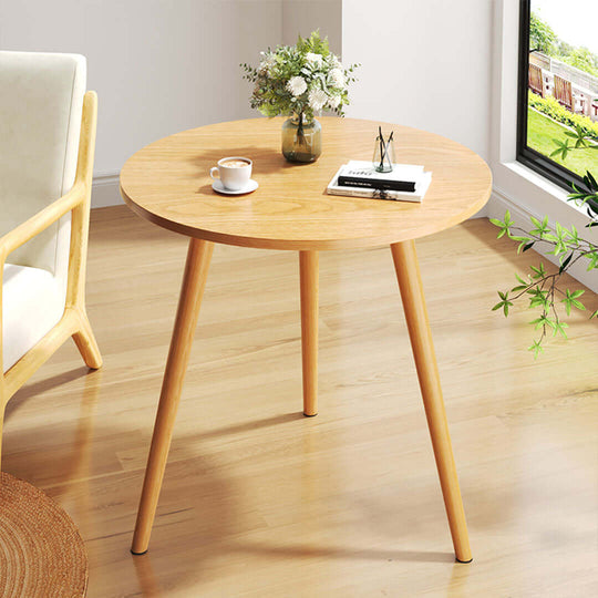 Affordable quality homewares - round wooden table with a vase, book, and coffee cup in a bright room. Value furniture for modern living.