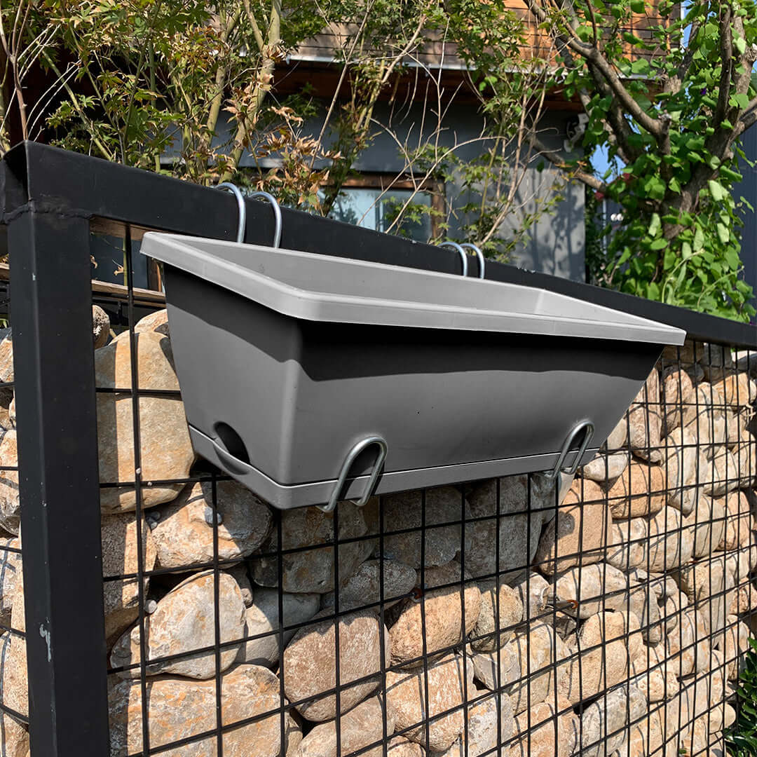 Affordable quality homeware planter box on a metal fence, showcasing value furniture for outdoor spaces.