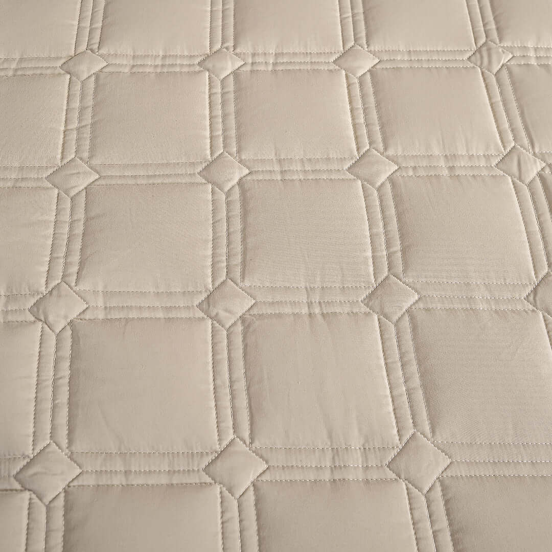 Textured beige fabric with a quilted square pattern.