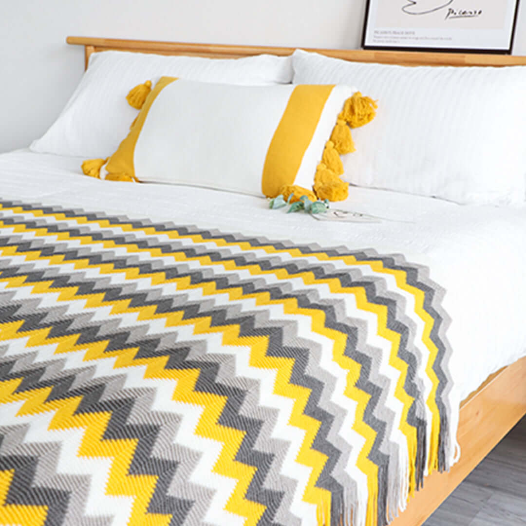 Affordable high-quality homewares including a value furniture bed with yellow, gray, and white chevron-patterned throw blanket.