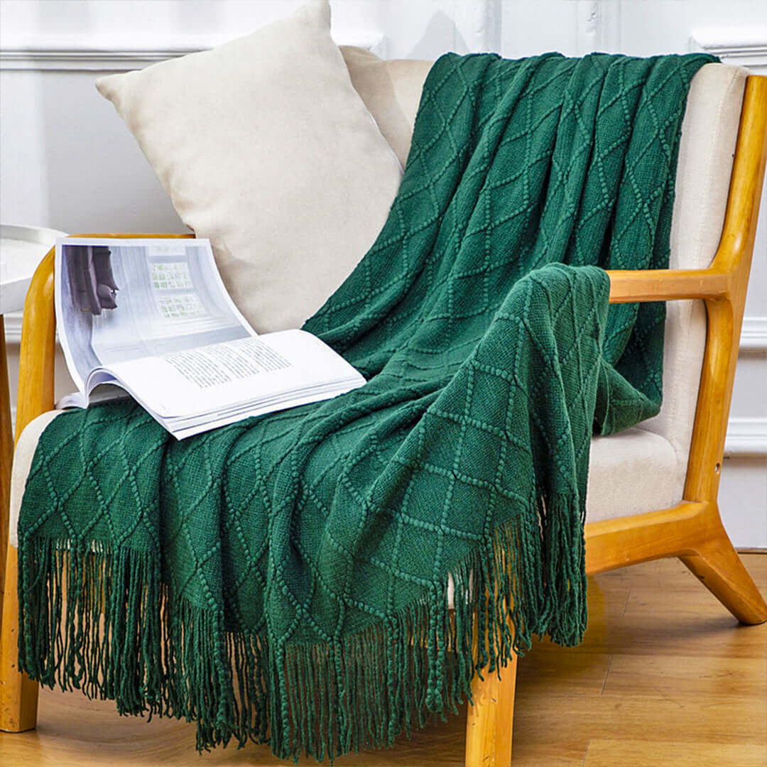 Affordable quality homewares - cozy green throw blanket on value furniture chair with an open book.