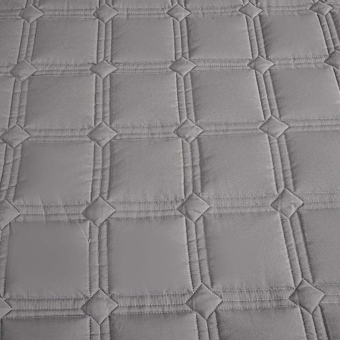 Grey diamond-patterned quilted fabric close-up showcasing quality, affordable homewares perfect for adding value to your furniture.