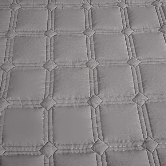 Grey diamond-patterned quilted fabric close-up showcasing quality, affordable homewares perfect for adding value to your furniture.