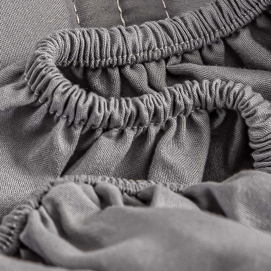 Close-up of high-quality affordable grey fitted sheet with elastic edges for value homewares and furniture.