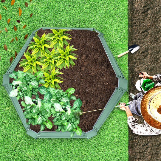 Person tending to plants in an octagonal garden bed on grass, showcasing affordable homewares for quality gardening.