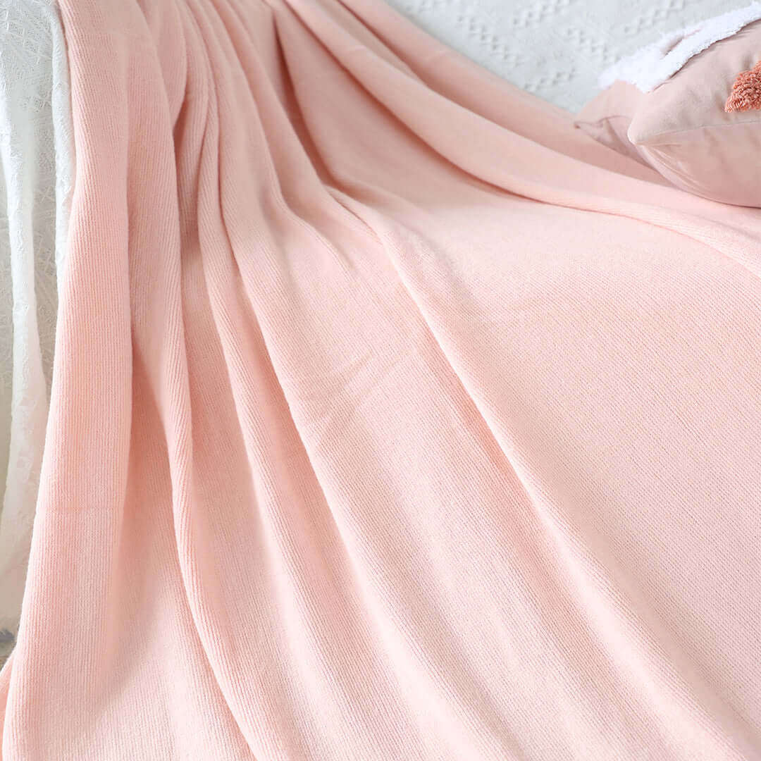 Soft peach throw blanket on bed offering affordable homewares and quality value furniture for a cozy bedroom setting