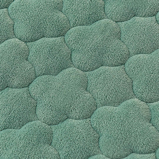 Green textured fabric with a soft, quilted pattern resembling overlapping flower petals, perfect for quality homewares and affordable value furniture.