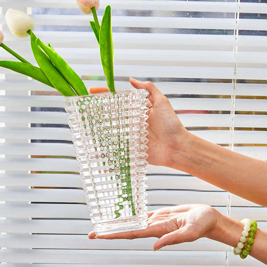 Affordable quality glass vase held up with green leaves and white flowers against window blinds, value homewares.