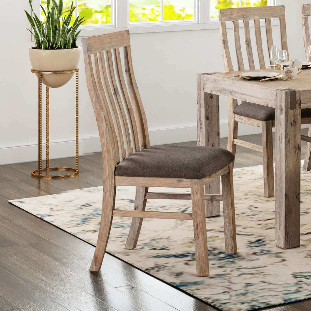 Wooden frame leatherette dining chair in oak color, placed around a dining table with a vintage look, next to a plant stand in a bright dining room.