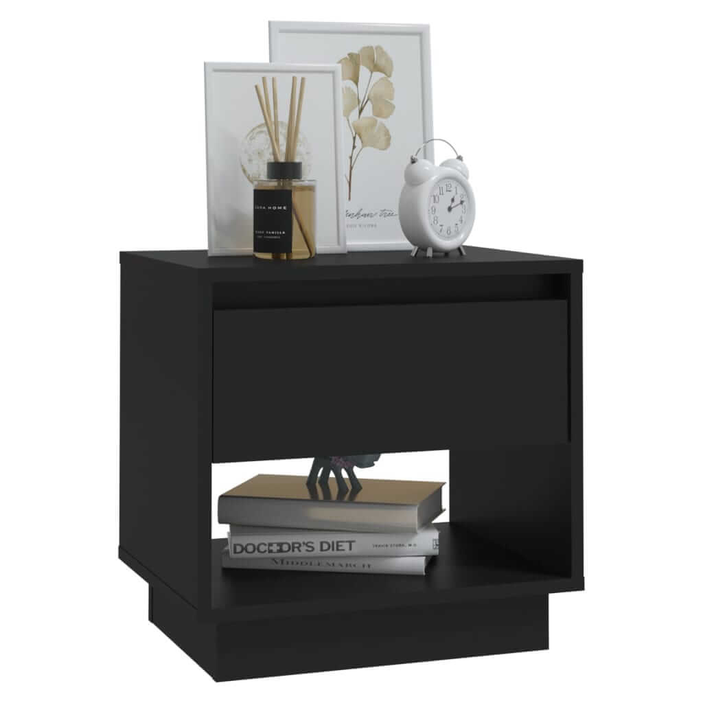 Black bedside cabinet with drawer and open compartment, featuring books, a clock, and decor items on top.