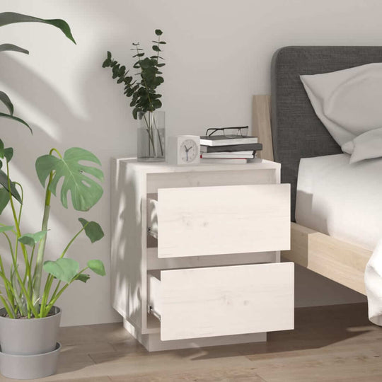 Affordable quality white bedside cabinet with two drawers in solid pine wood, enhancing modern room decor, shown next to bed with plants.