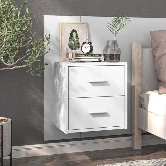 High gloss white wall-mounted bedside cabinet with two drawers next to a bed, displaying decor items, offering affordable and quality storage solutions