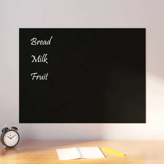 Wall-mounted black magnetic board with a grocery list, clock, and notebook on desk. Affordable, quality DIY home office accessory.