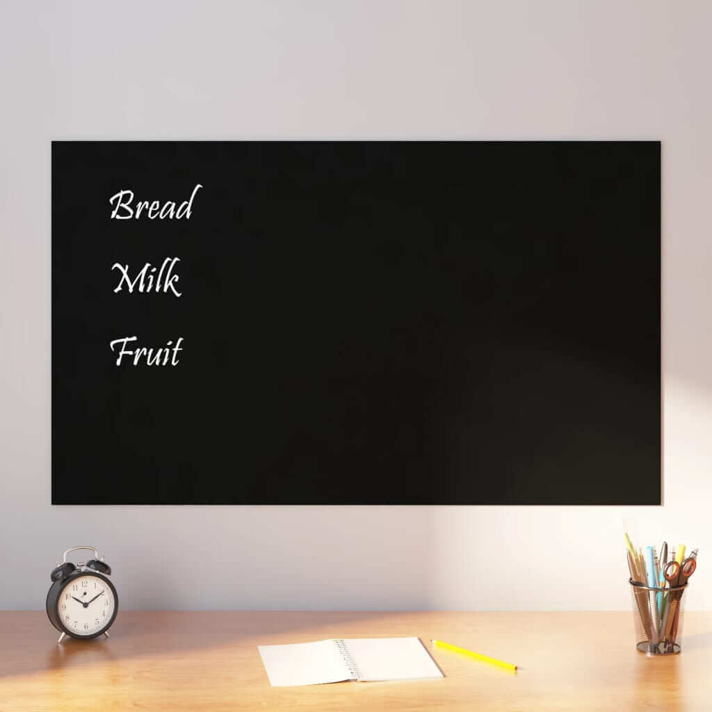 Wall-mounted black magnetic board with shopping list, on a desk with a clock, open notebook, and pencil, showcasing its DIY appeal.