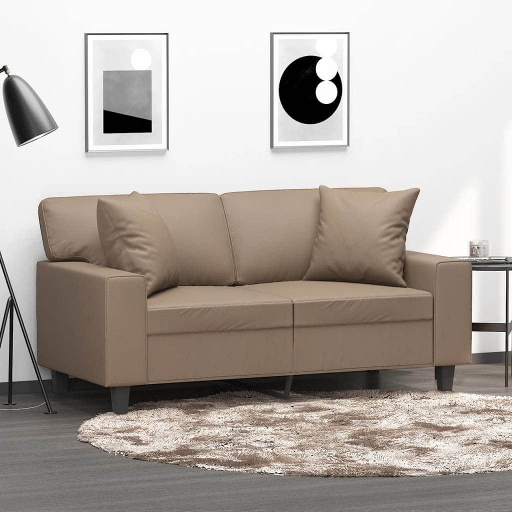 Modern living room with a cappuccino faux leather sofa and matching throw pillows on a stylish rug.