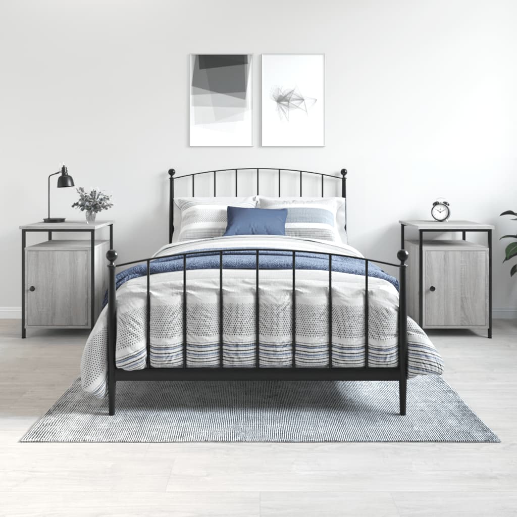 Grey Sonoma bedside cabinets in a bedroom setting with black iron bed frame, lamps, and artwork on the wall. Affordable and quality storage solution.