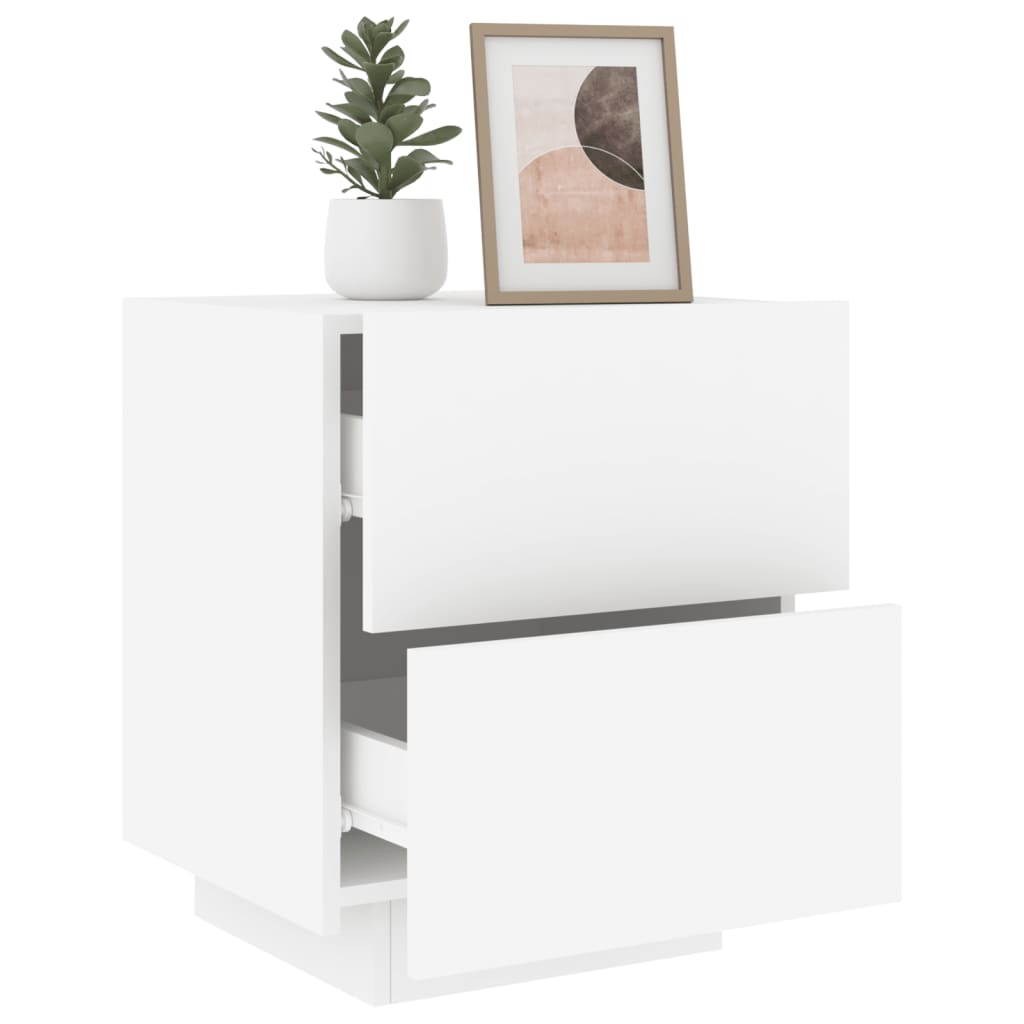 White bedside cabinet with open drawer, topped with a potted plant and framed artwork. Affordable, quality, engineered wood furniture.