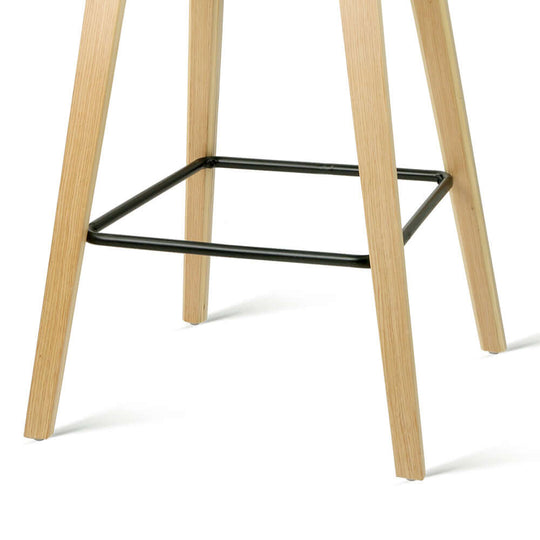 Close-up of Bar Stool's wooden legs with black metal footrest support, showcasing durable and stylish design.