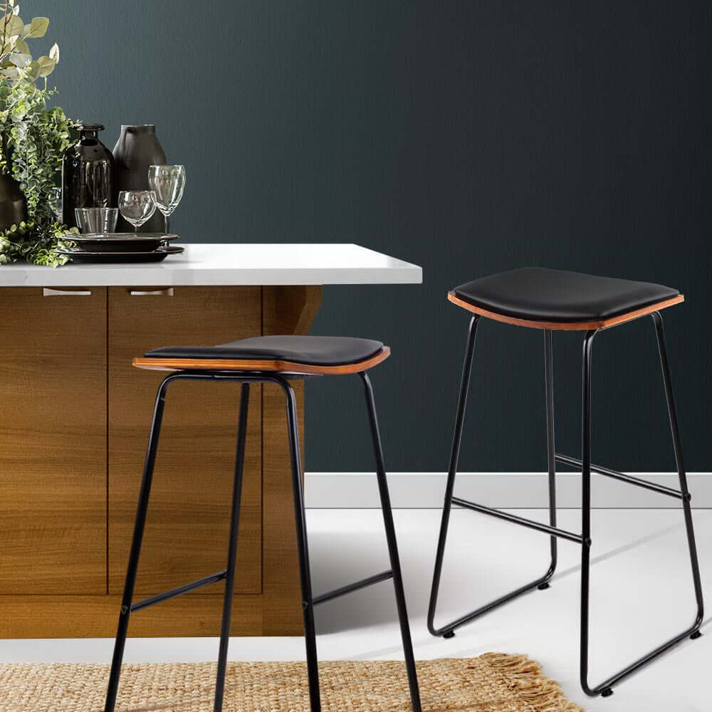 Stylish Artiss 4x bar stools with leather padding and metal frame in modern kitchen setting.