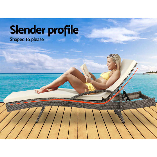 Woman relaxing on Gardeon sun lounge by the beach, featured with grey and beige cushions for ultimate comfort.